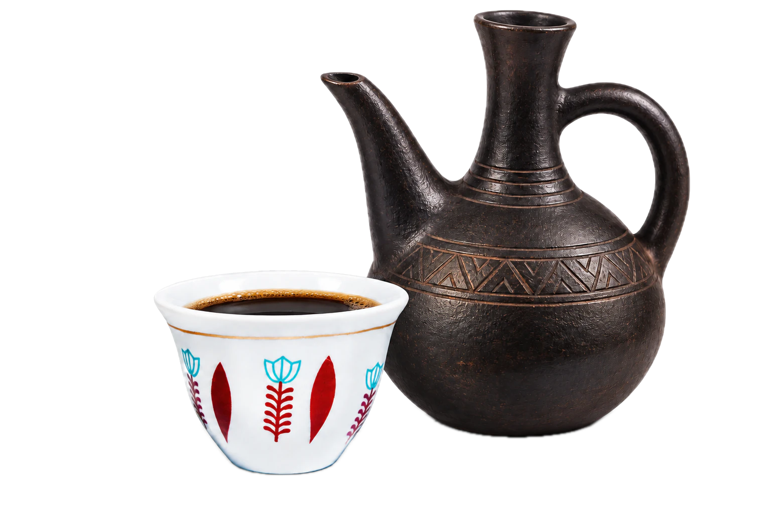 Black coffee in a white Ethiopian cup with red and turquoise decoration beside a black clay jebena